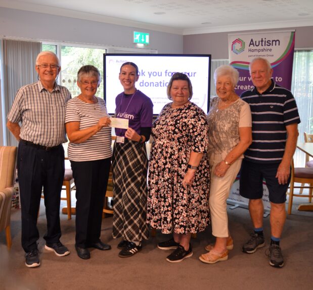 Residents present Autism Hampshire with cheque from bingo session.
